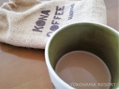 コナコーヒーの入ったコーヒーカップとコーヒー豆の袋