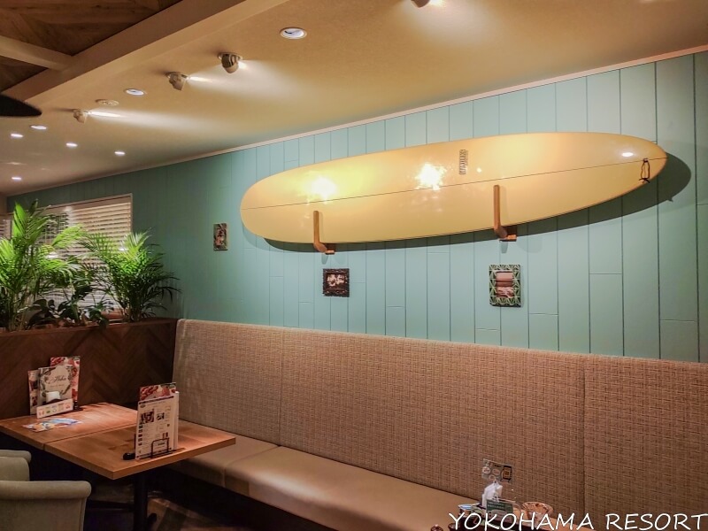店内の壁に飾られているクリーム色のロングサーフボード