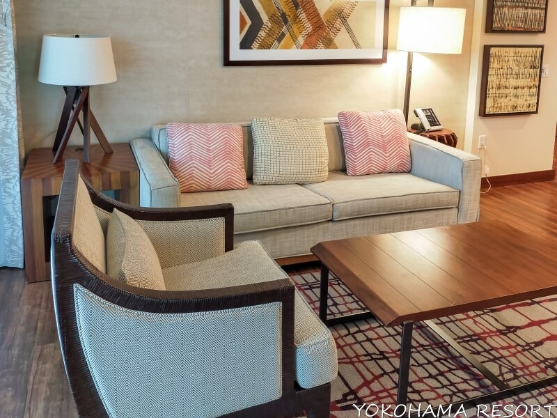 ザ・グランド・アイランダー 2BR リビングルームに大きなソファーと1人掛けソファーと木製のローテーブル