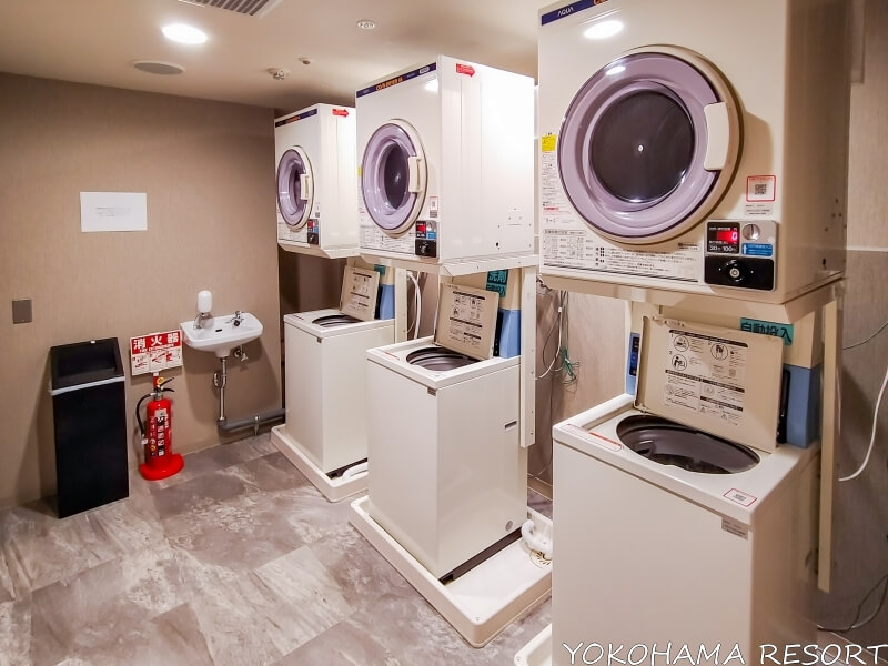白い洗濯機と乾燥機が３台ずつあるランドリールーム