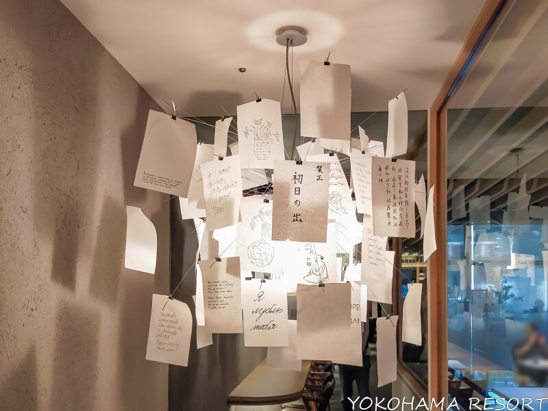 メッセージが掛かれたたくさんの紙がライトの周りに吊り下げられている