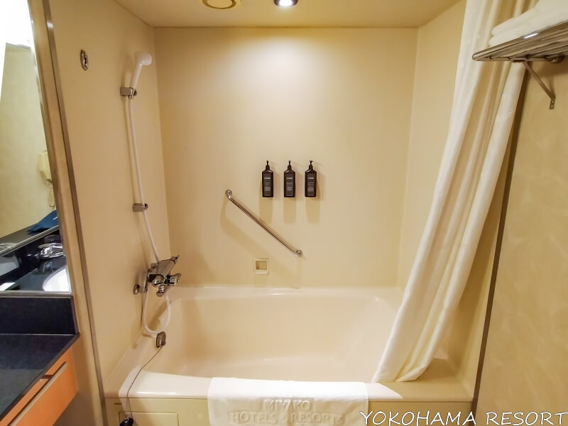 浴槽にはハンドシャワー、シャワーカーテンがあり、シャンプー類のボトルは壁に備えついている
