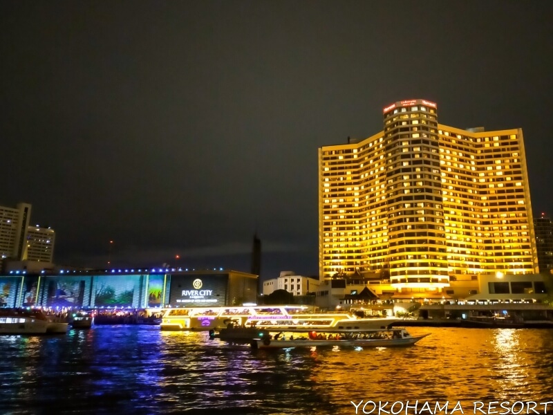 夜に輝く大きなロイヤルオーキッド・シェラトン・ホテル＆タワーズとリバーシティの建物