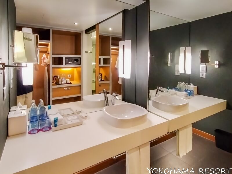白く広い洗面台と壁一面の大きな鏡