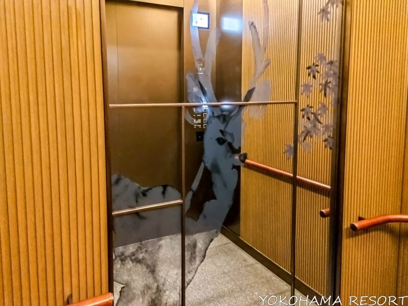 エレベーター内の鏡に描かれた鹿と紅葉
