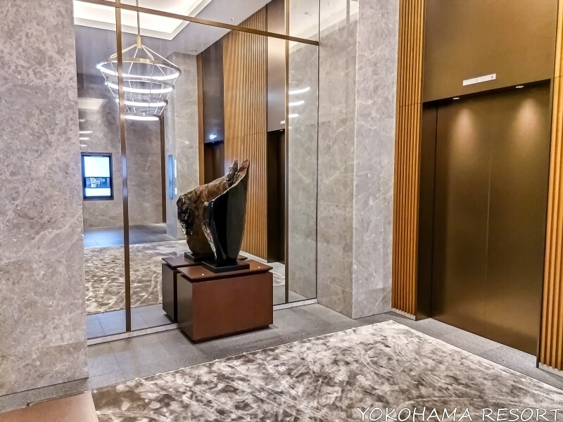 エレベーターホールに大きな鏡と置物