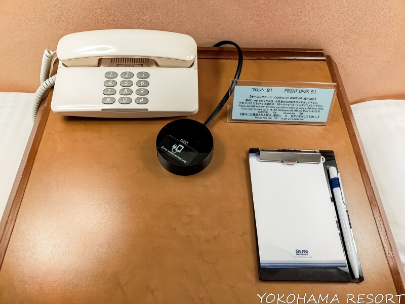 ベッドの間のサイドテーブルに電話と延長コードとメモ帳
