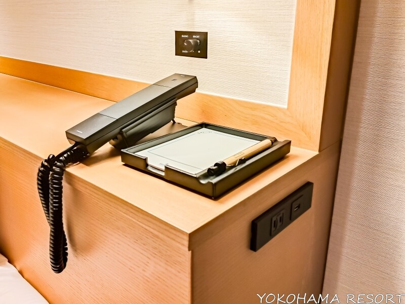 ベッドサイドのメモ帳と電話